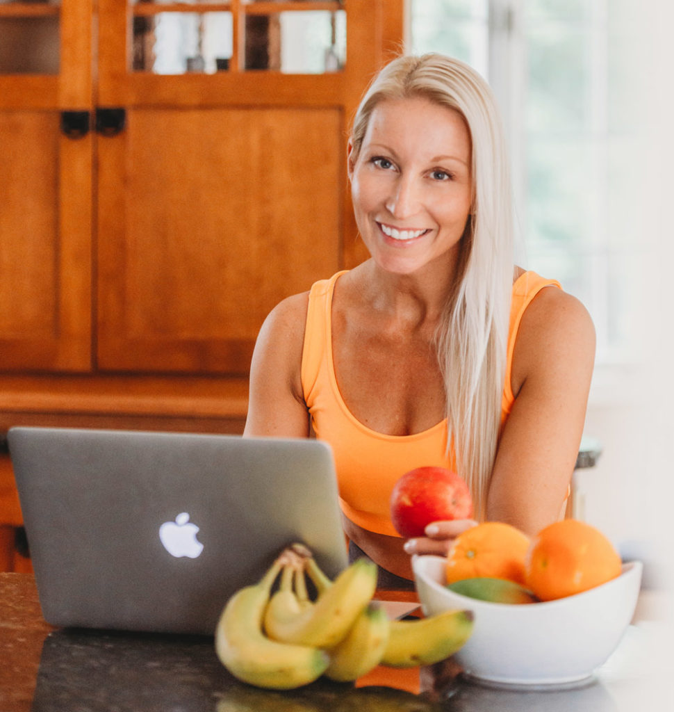 Ingrid Segev sitting on computer with fruit in her home.